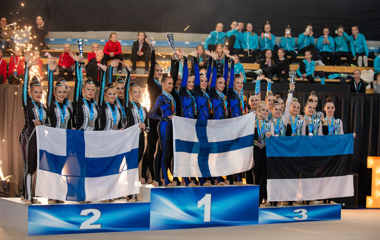 Naisten sarjan joukkueet palkintopallilla joukkuevoimistelun maailmancupissa Espoossa.
